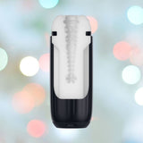 The Svakom Sam Neo 2 Sucking and Vibrating Masturbator, a sleek black and white cylindrical device with a textured interior, is showcased against a softly blurred background of multicolored lights, providing enhanced suction for a personalized experience.