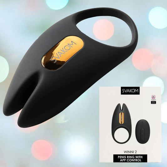 The "Svakom Winni 2 Penis Ring w/ App Control (Black)" by Svakom is a black, silicone vibrating ring with a gold accent. The packaging showcases the product prominently, emphasizing its function as an app-controlled couples' toy set against a softly blurred pastel backdrop. 1080