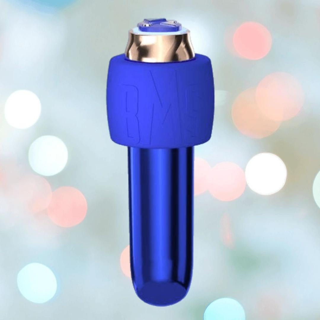 The Swan Maximum Rechargeable Bullet by BMS, in blue with a metallic top, rests against a background of softly blurred pastel lights.