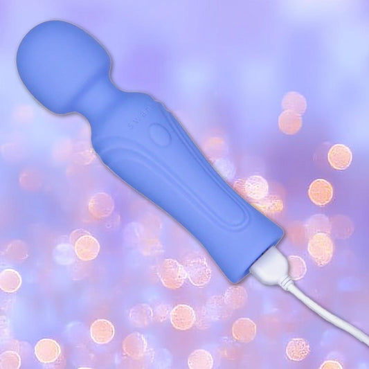 The Swan Era Wand by BMS is a blue handheld massager with a rounded head and cord, powered by a PowerBullet motor. It’s shown against a soft purple background with glowing bokeh lights. 1080