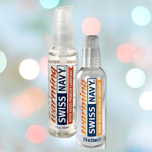 Two bottles of Swiss Navy Premium Warming Lubricant are showcased against a blurred background featuring colorful lights. One bottle contains 4 fl oz (118 ml) and the other 2 fl oz (59 ml), both offering the premium, soothing sensation of a water-based warming lubricant from Swiss Navy. 1080