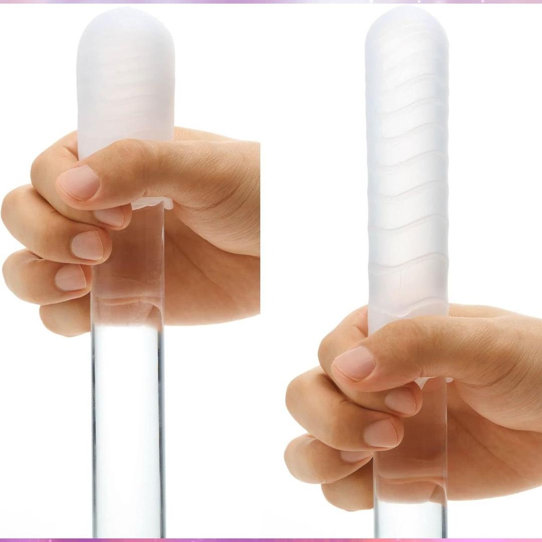 Two hands hold the TENGA Pocket Click Ball, a disposable textured male masturbator by Tenga. Its pocket-sized, super-stretchy elastomer design is displayed from two angles against a plain background.