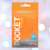 A bright orange, resealable pouch labeled "Tenga Pocket Hexa Brick" features a hexagonal pattern and contains the Tenga Pocket Hexa Brick, a disposable textured male masturbator, shown against a blurred background with pastel lights.