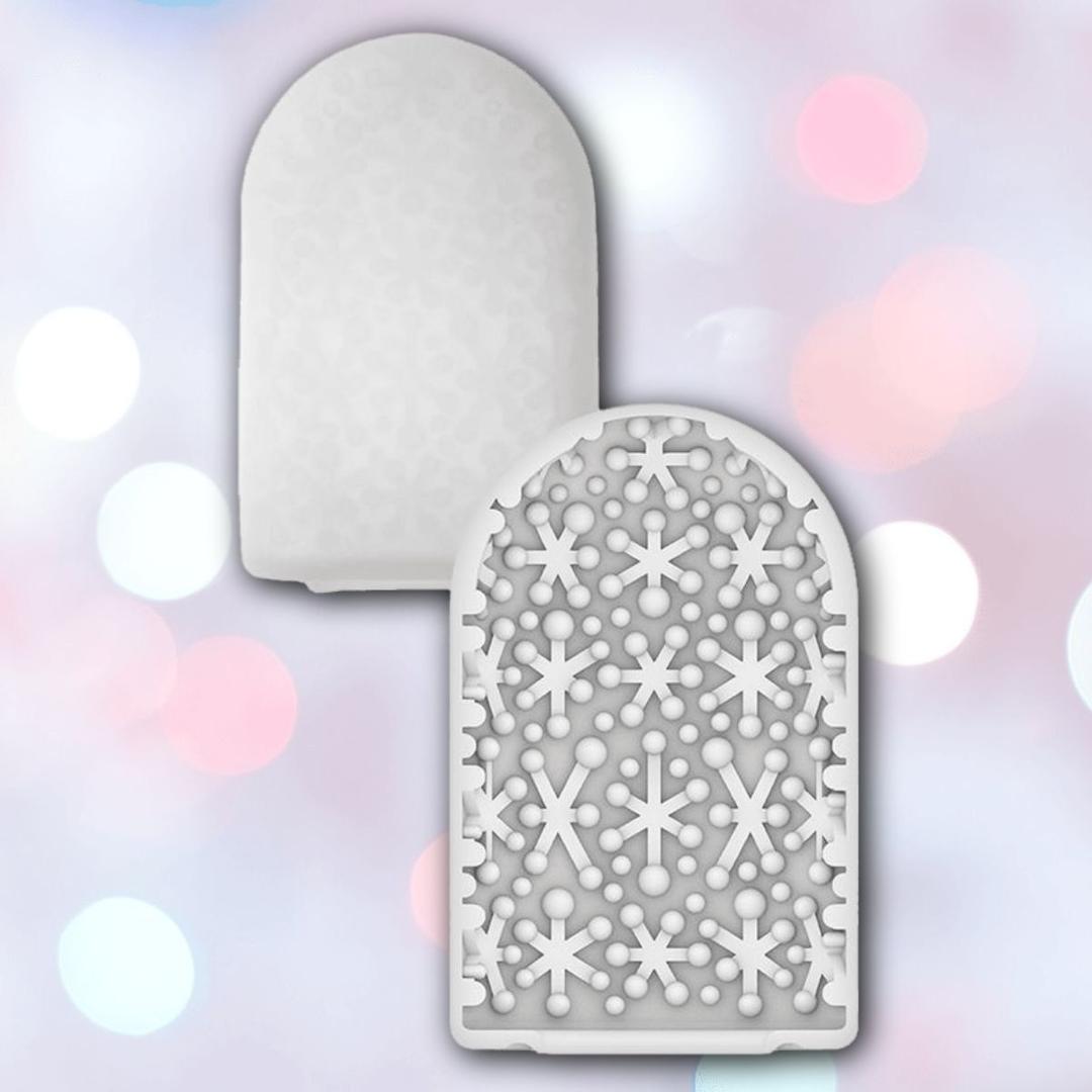Two white, dome-shaped air freshener inserts with a pattern of holes and snowflake-like cutouts are shown against a soft, pastel bokeh background—echoing the sleek look of Tenga Pocket Spark Beads Disposable Male Masturbation Sleeve by Tenga.