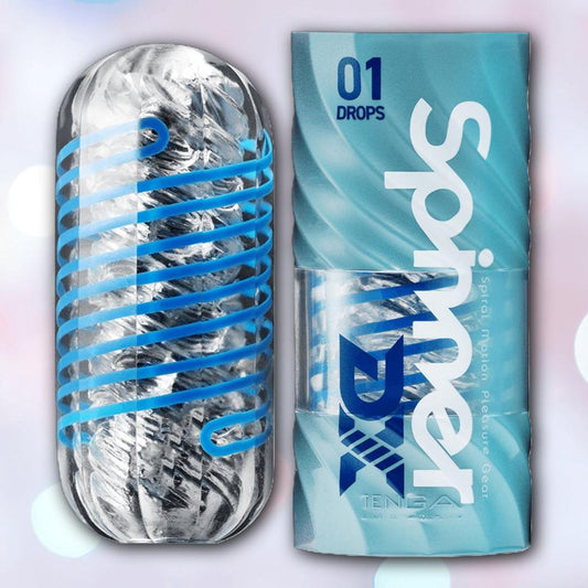 The Tenga Spinner DX 01 Drops is a clear, textured cylindrical reusable stroker with a blue spiral inside for spinning sensations, shown next to its blue and white Tenga packaging labeled "Spinner Motion Pleasure Gear. 1080