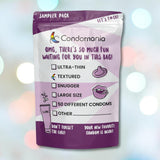 A Condomania Textured Condom Sampler (Ribbed & Studded Condoms) is displayed against a softly blurred background with light spots, featuring its purple and white packaging. Colorful text highlights options like Textured and Ribbed Condoms with checkboxes and a gentle reminder about lube.