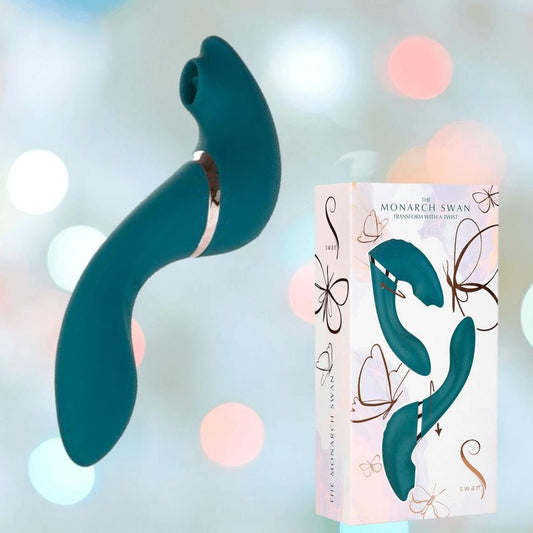 The Monarch Swan - Teal by BMS, a curved G-spot vibrator, is shown beside its white box featuring butterfly art and a product image. The softly blurred background glows with pastel lights. 1080