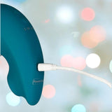 A close-up of the BMS Swan The Monarch Swan in teal being charged with a white cable, set against a blurred background featuring colorful bokeh lights.