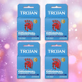 Four blue boxes of Trojan ENZ Condoms Without Lube by Trojan are arranged in a square on a pink and purple bokeh background. Each box displays a red Trojan helmet logo and white text emphasizing the non-lubricated feature.