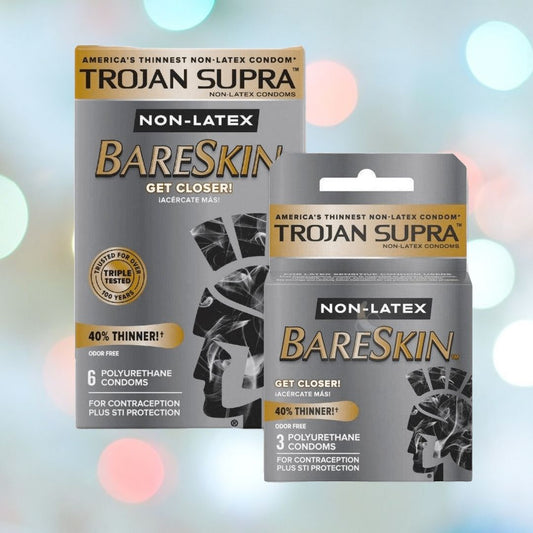 Displayed against a gentle, blurry backdrop, boxes of Trojan Supra Bareskin Condoms from the Trojan brand feature premium polyurethane construction. The packaging emphasizes benefits such as "40% thinner," and they are available in packs of 6 or 3 condoms. 1080