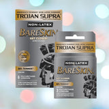 Displayed against a gentle, blurry backdrop, boxes of Trojan Supra Bareskin Condoms from the Trojan brand feature premium polyurethane construction. The packaging emphasizes benefits such as "40% thinner," and they are available in packs of 6 or 3 condoms.