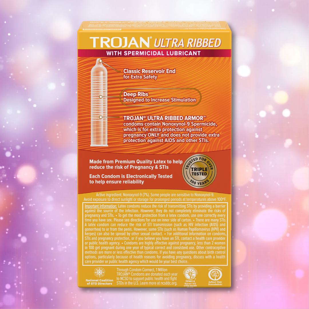 A box of Trojan Ultra Ribbed Armor Condoms by Trojan is shown against a pink and purple abstract bokeh background, with product features and information visible on the back of the box.
