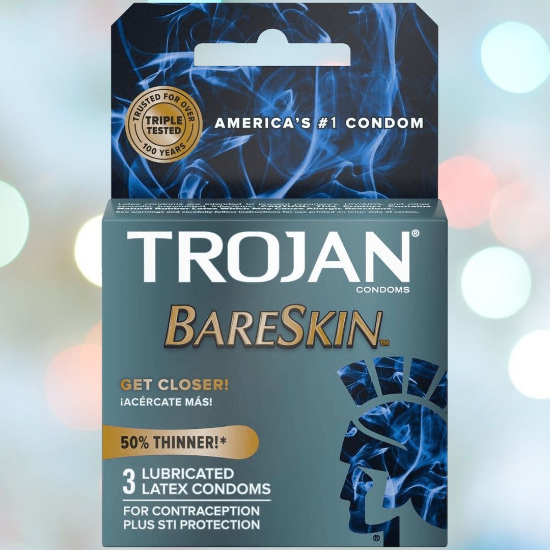 Trojan BareSkin Ultra Thin Condoms, adorned with a blue flame design, feature the slogans "Get Closer!", "50% Thinner!", and include "3 Lubricated Latex Condoms for Contraception Plus STI Protection." The top label highlights "America's #1 Condom" and emphasizes being "Triple Tested" for maximum safety.