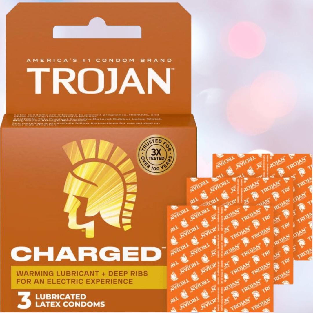 A box of Trojan Charged Deep-Ribbed Condoms by Trojan with “warming lubricant + deep ribs” text, shown alongside three individually wrapped condoms on a light pink background.