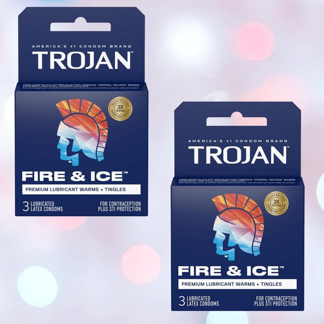 Two boxes of Trojan Fire and Ice Condoms (Hot & Cold Condom) by Trojan rest on a soft pastel background with pink and white bokeh circles, featuring bold blue and red Trojan helmet graphics.