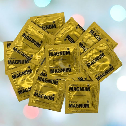 A heap of Trojan Magnum Condoms, known for their generous size and comfort-fit design, is laid out against a blurred background with circular light patterns. 1080