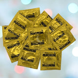 A heap of Trojan Magnum Condoms, known for their generous size and comfort-fit design, is laid out against a blurred background with circular light patterns.