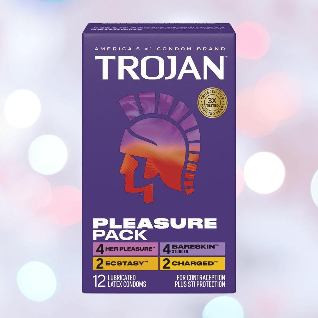 The Trojan Pleasure Pack Variety Condom Sampler by Trojan features a purple box with the orange helmet logo and includes 12 lubricated latex condoms in four types: Her Pleasure, Ecstasy, BareSkin Studded, and Charged.