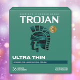 A box of Trojan Ultra Thin Lubricated Condoms from Trojan, shown against a teal background and displaying the silhouette of a Trojan soldier’s helmet. The packaging reads “36 lubricated latex condoms” and highlights that these ultra thin condoms are designed for heightened sensitivity, comfort, and a more natural feeling.