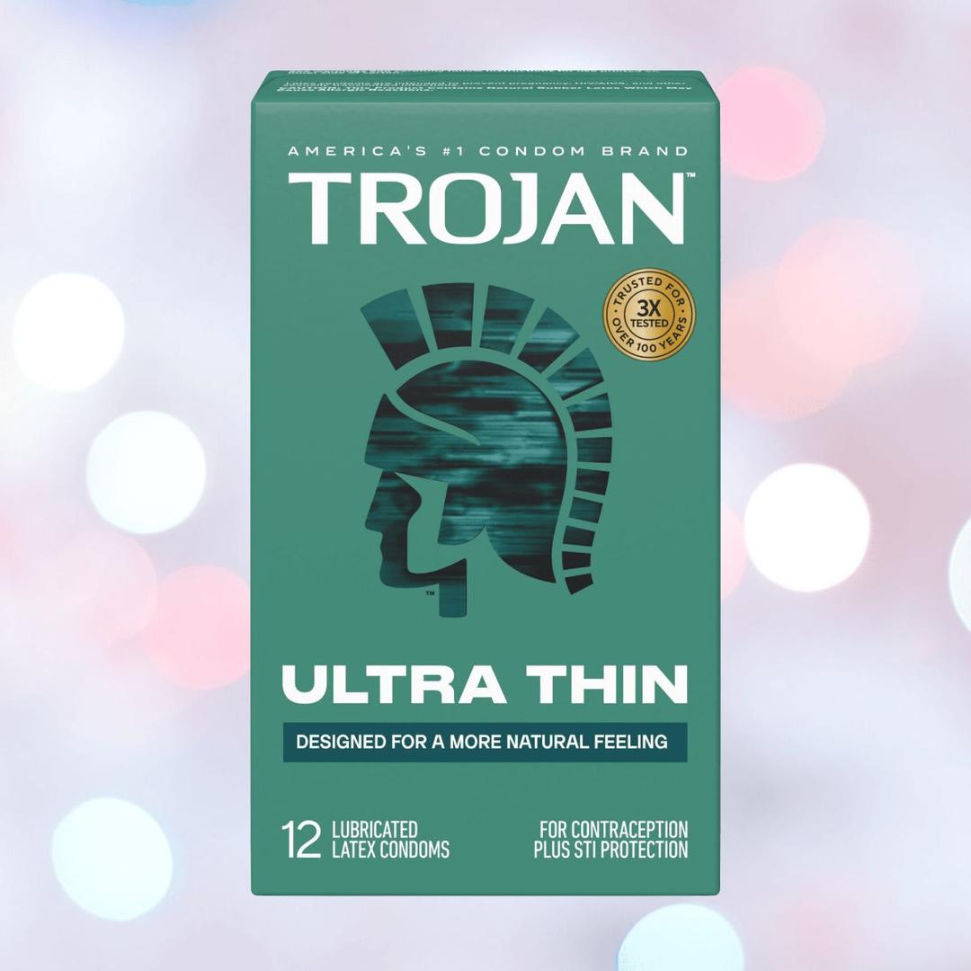 A green box of Trojan Ultra Thin Lubricated Condoms displays a Trojan helmet silhouette. This 12-count pack offers ultra-thin condoms for a natural feel, designed by Trojan for contraception and STI protection.