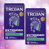 Two boxes of Trojan Extended Pleasure Climax Control Condoms by Trojan, each featuring 12 lubricated latex condoms with a climax control lubricant and a stylized helmet design on a pink and purple bokeh background.