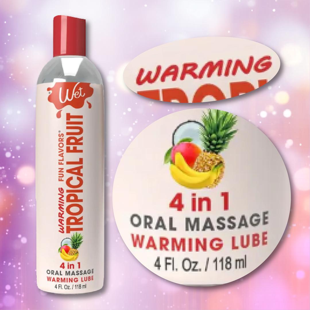 A bottle of Wet "Tropical Fruit" Flavored Warming 4 in 1 Lubricant 🍍 is displayed with a close-up of its vibrant tropical fruit label and product details, set against a soft pink background.