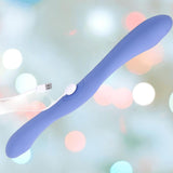 The Doc Johnson Tryst Duet Double-Ended Silicone Vibrating Dildo in periwinkle features two rounded ends and a wireless remote, shown with a USB charging cable against a soft, blurred pastel background.