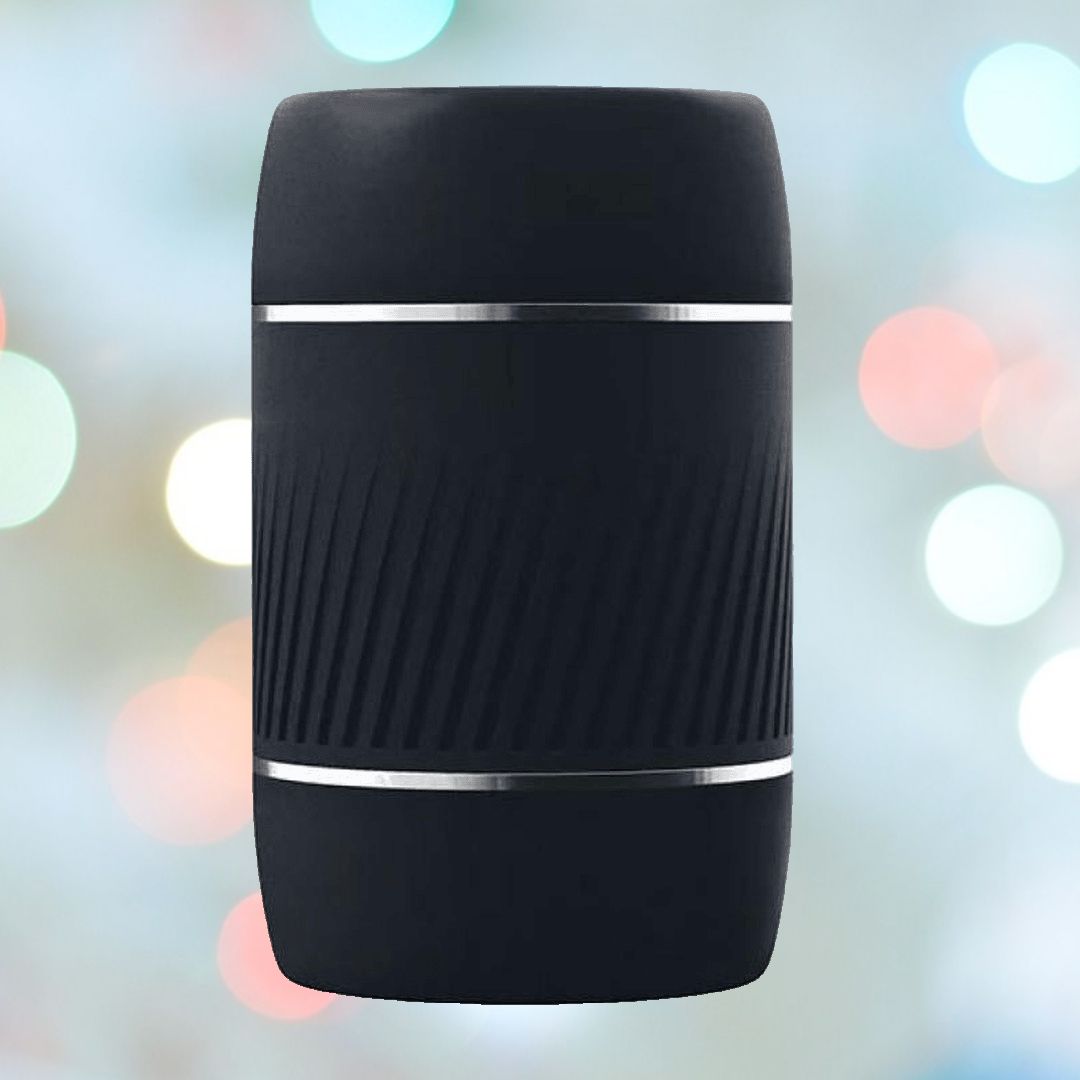 The black, cylindrical smart speaker, echoing the design of the VeDO Jerk Masturbation Sleeve with its textured ribbed midsection and silver accents, is positioned against a backdrop featuring a soft bokeh effect in pastel hues.