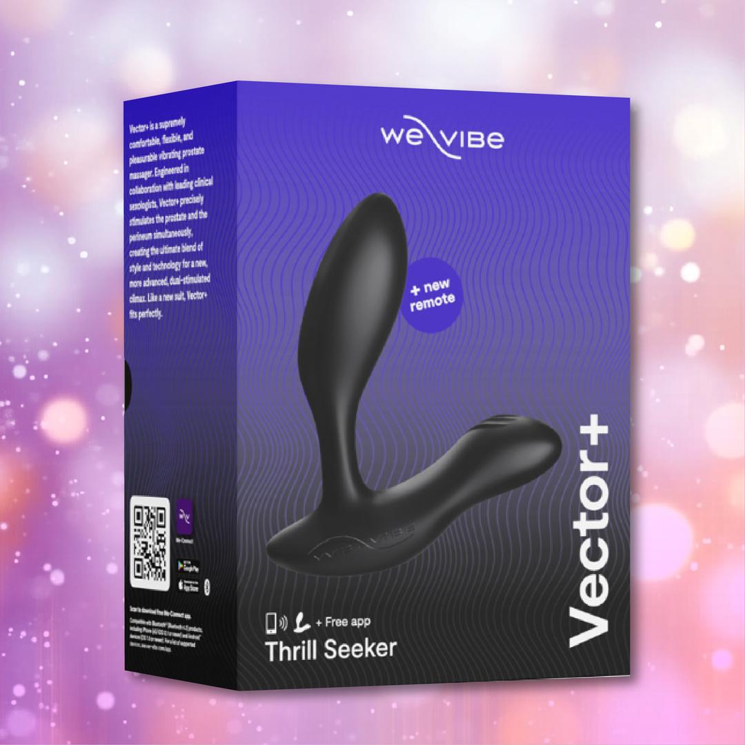 A charcoal black box features the We-Vibe Vector+ Vibrating Prostate Massager by We-Vibe with a wireless remote. The packaging shows product images, app compatibility icons, and text against a blurred pink and purple sparkly background.