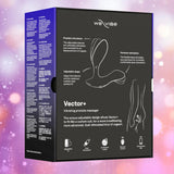Black box packaging for the We-Vibe Vector+ Vibrating Prostate Massager - Charcoal Black by We-Vibe, with product illustrations, features, and icons on a soft pink and purple bokeh background.