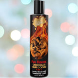 A bottle of Wet Desserts 'Chocolate Chip Cookie' Warming Lubricant 🍪, with its enticing aroma of freshly baked cookies, is set against a background of softly illuminated colors. The label features a vibrant image of a flaming chocolate chip cookie, making it an ideal choice for an irresistible edible experience during intimate moments.