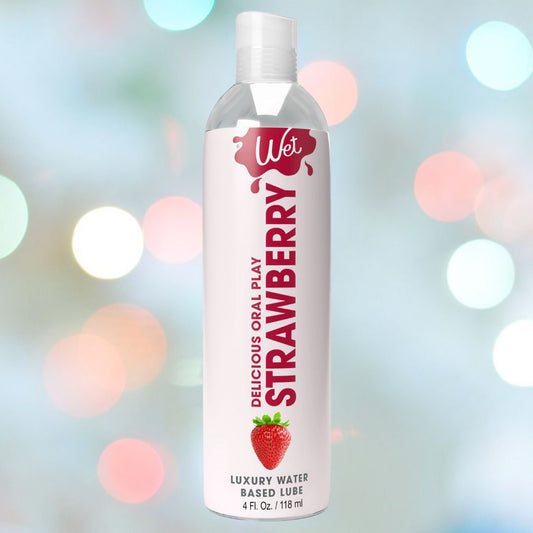 A bottle of Wet Delicious Oral Play Strawberry flavored lubricant is displayed against a vibrant, blurred backdrop of colorful lights. It features 4 fl. oz. (118 ml) of enticing lubricant for enjoyable moments. 1080