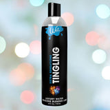 A 4 fl. oz. (118 ml) black bottle of Wet Extra Sensations Tingling Water/Silicone Blend Based Lubricant stands upright amid colorful spark graphics on a pastel bokeh background, showcasing its hybrid formula with peppermint extract.