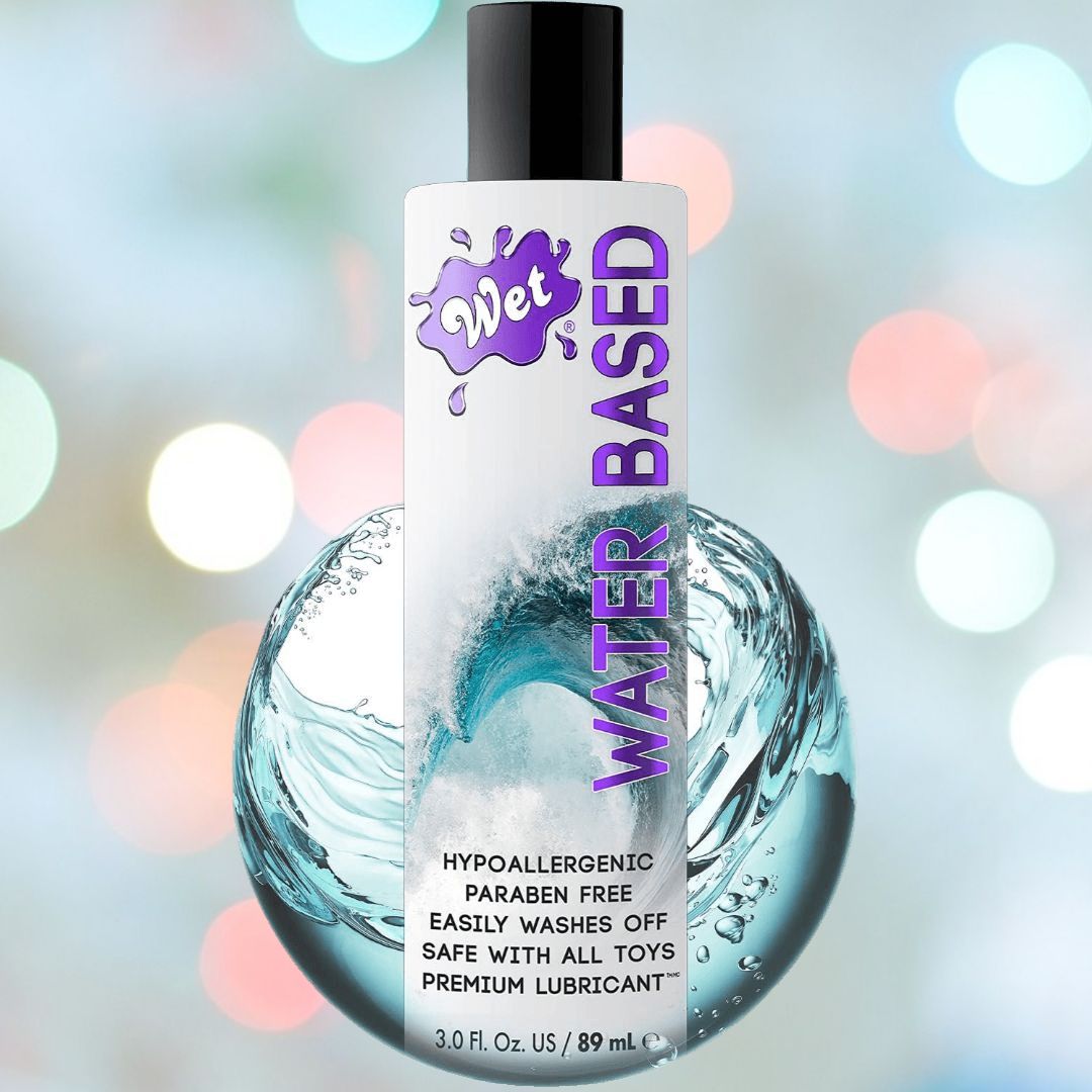 A bottle of "Wet Original Gel Water-Based Lubricant" features a splash design on the label. The 3.0 fl. oz. (89 ml) bottle is showcased against a bokeh background, emphasizing that it is hypoallergenic, paraben-free, sex toy compatible, and easy to wash off.
