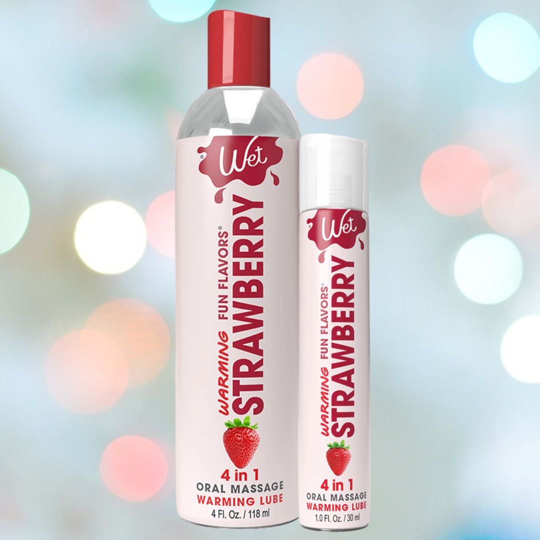 Set against a vibrant, blurred backdrop, two bottles of Wet "Sexy Strawberry" Warming Lubricant 🍓 effortlessly draw attention. The larger bottle contains 4 fl oz, while the handy travel-sized version offers 1 fl oz. Adorned with bold strawberry graphics and red caps, these are perfect as fragrant massage lotions.