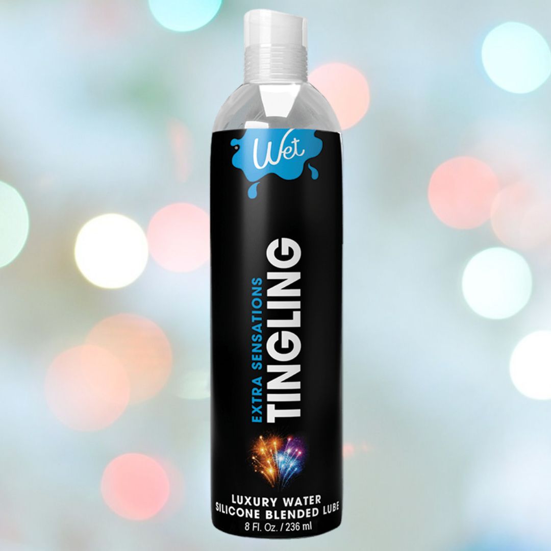 A black bottle of Wet Extra Sensations Tingling Water/Silicone Blend Based Lubricant by Wet is shown against a blurred, colorful background with circular light spots.