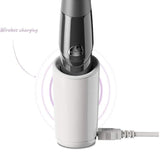 The Zumio E Clitoral Stimulator - Black by ZUMIO, INC stands upright in its white charging dock with a plugged-in cord. "Wireless charging" text and purple lines highlight its pressure-sensitive, precise stimulation features.