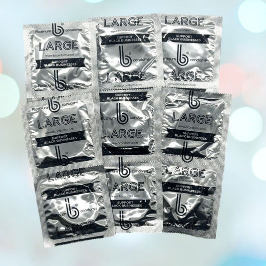 Nine packets of Condomania's Free Sample: b Condoms Platinum Large Condoms (Limit 1), labeled "LARGE" and "SUPPORT BLACK BUSINESSES," are displayed in a grid on a softly blurred background with blue and white lights. 1080