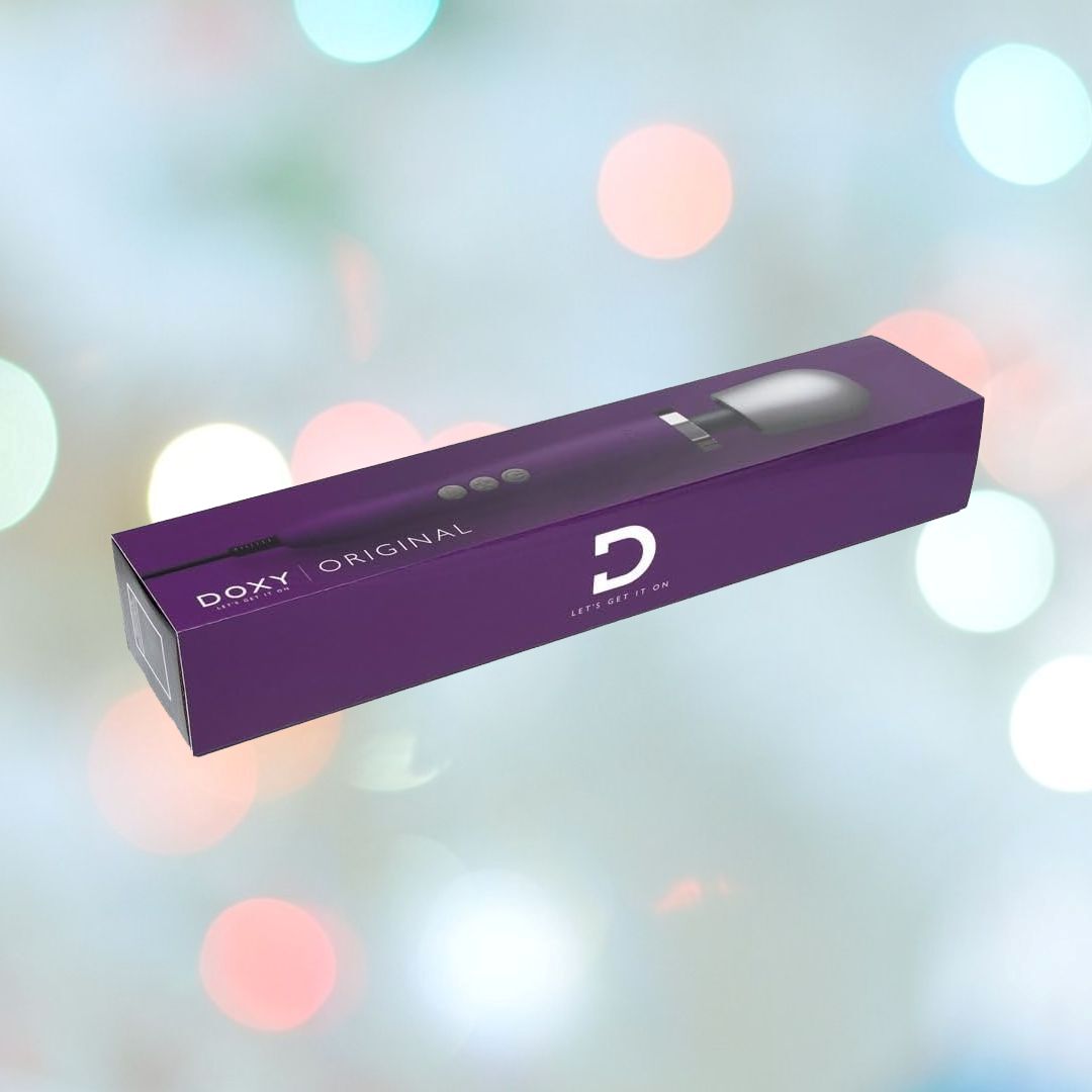 A purple box labeled "DOXY ORIGINAL" with an image of the Doxy Original Wand Massager - Purple is displayed against a background with colorful, out-of-focus lights. The box features the letter "D," the phrase "LET’S GET IT ON," and highlights its intense vibrations.