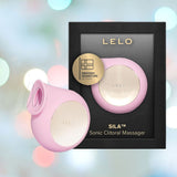 A pink LELO SILA Air Suction Clitoral Massager, made from extra-soft silicone and featuring a gold accent, is showcased alongside its black packaging. The packaging highlights a gold badge stating "Swedish Signature Design," surrounded by a gentle blur of blue and gray tones.