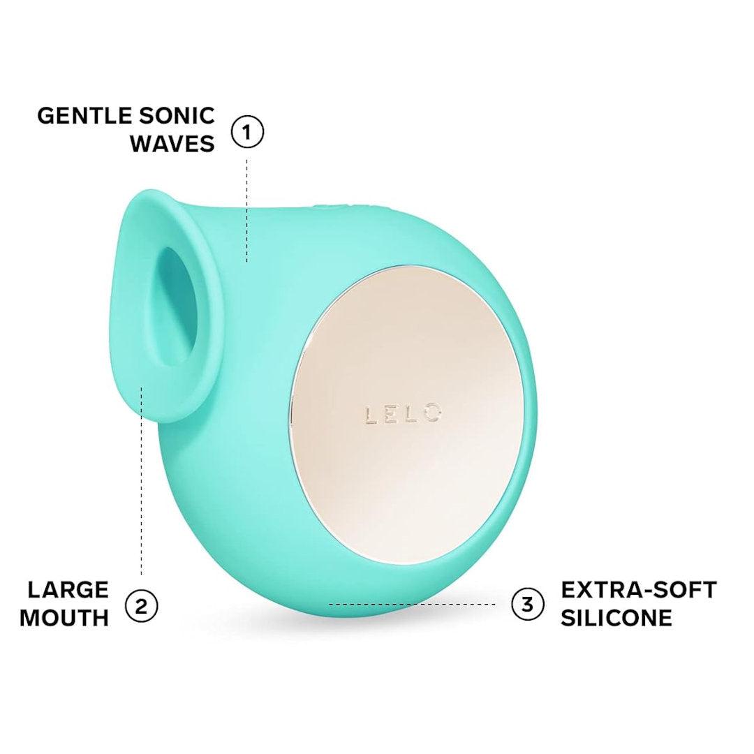 An aqua, rounded LELO SILA Air Suction Clit Massager with a large mouth opening on one side and a shiny metallic circular surface on the other. The image highlights features such as "Gentle Sonic Waves," "Large Mouth," "Extra-Soft Silicone," and its waterproof design for enhanced clitoral stimulation.