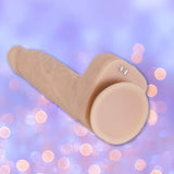 The BMS Naked Addiction Thrusting Dong - Vanilla 8.5" is displayed in a realistic, skin-toned design with textured details, set against a soft purple background with blurred bokeh lights.