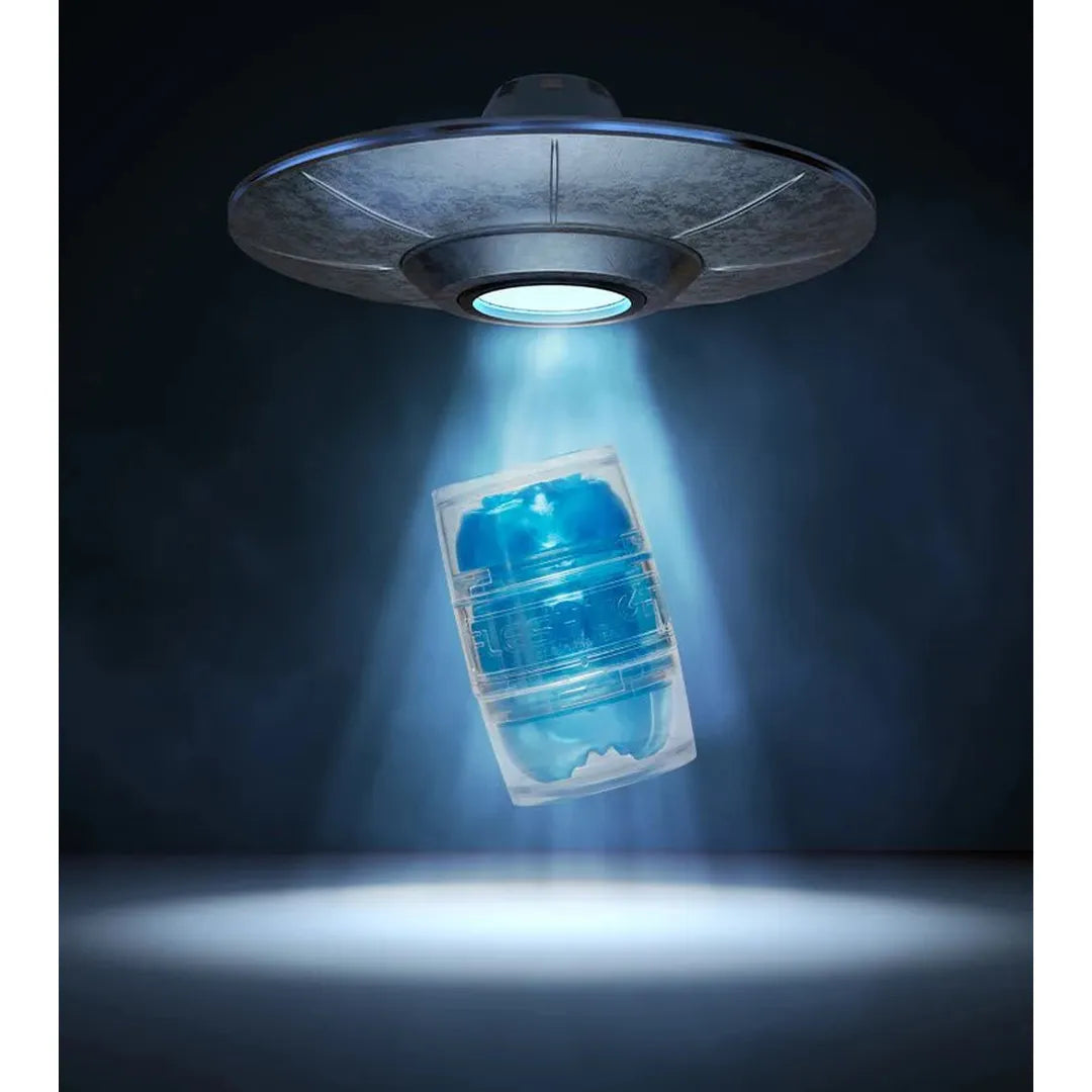 A metallic UFO beams down on the Fleshlight Quickshot Alien Blue Male Masturbator by Fleshlight, levitating its travel-friendly sleeve as blue light and mist create a mysterious, otherworldly scene.