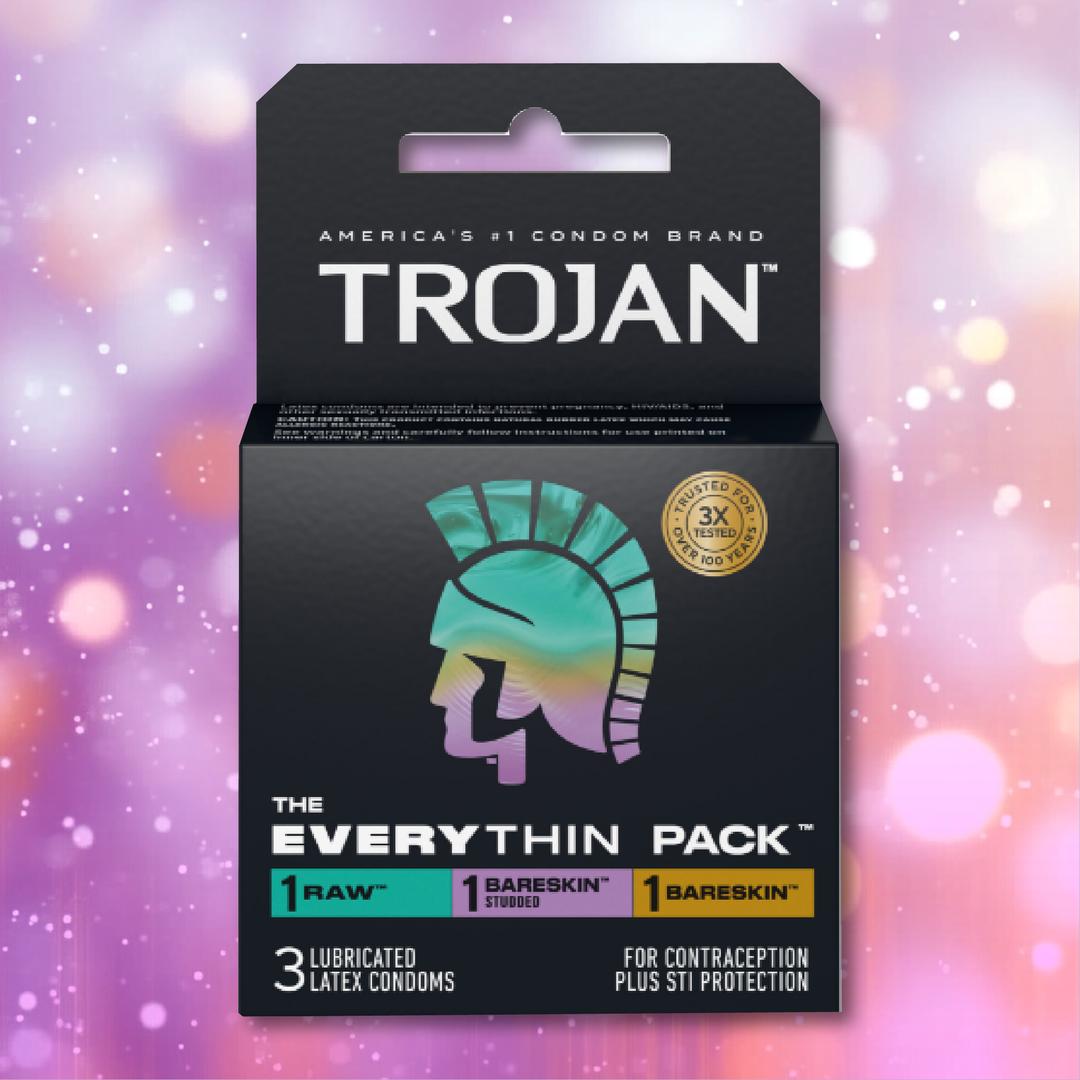 The Trojan Bareskin EveryTHIN Pack (Variety Pack) by Trojan contains 3 lubricated latex condoms—1 Raw, 1 BareSkin, and 1 BareSkin Thin—in a sleek black box with a holographic helmet logo and vibrant lights background.