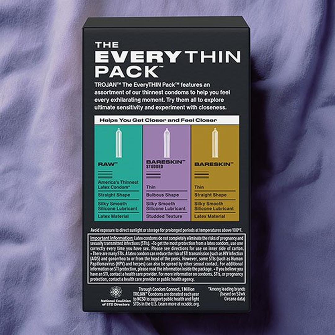 A box of Trojan Bareskin EveryTHIN Pack (Variety Pack) by Trojan sits on a purple surface, showing details and icons for RAW, BareSkin Studded, and Straight ultra thin condoms.