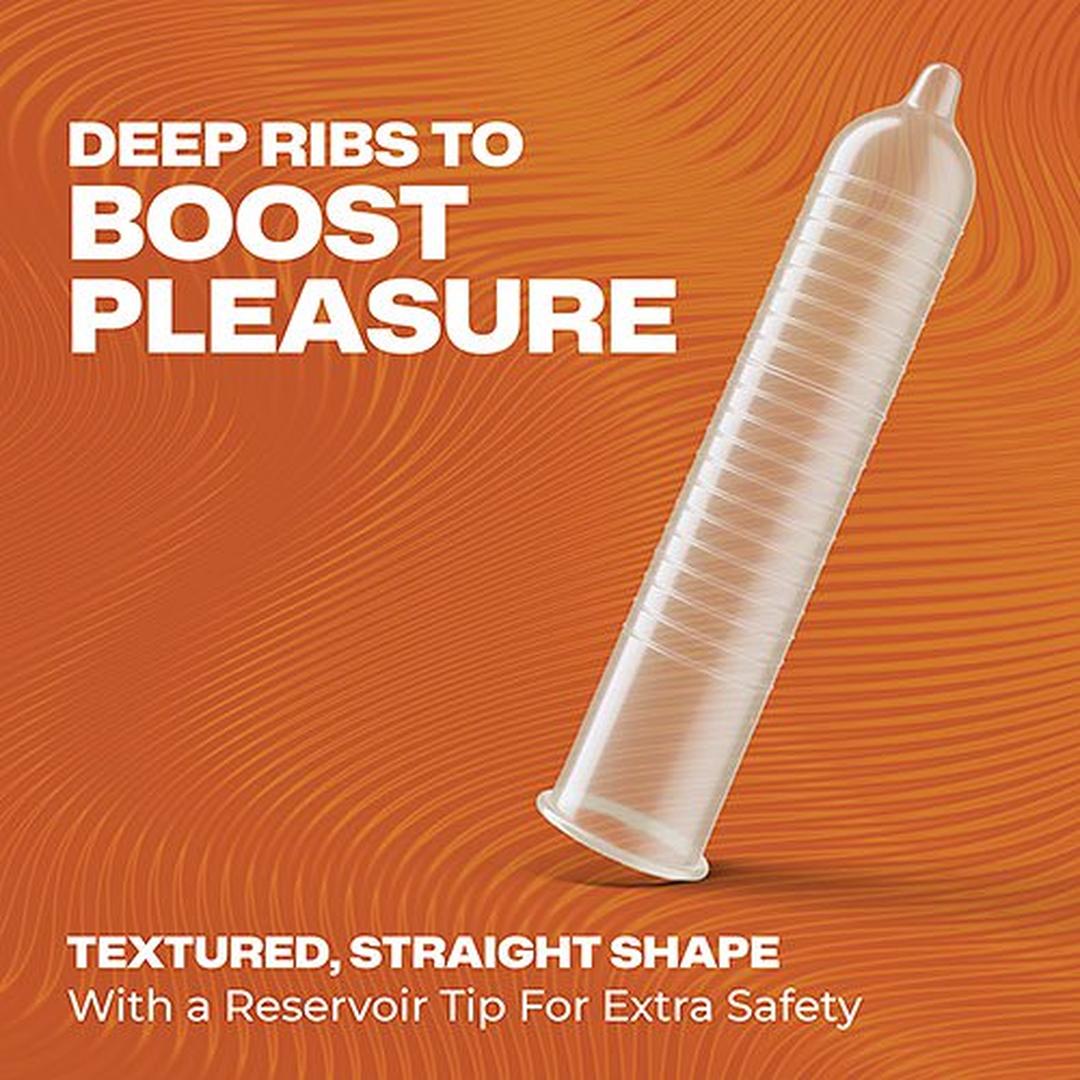 A Trojan Ultra Ribbed Condom is shown on an orange, wavy background. Text reads: “Deep ribs to boost pleasure.” These lubricated latex condoms from Trojan feature a straight shape and reservoir tip for extra safety.