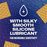 Blue background with water droplets, three Trojan Ultra Ribbed condom wrappers in the corners, and bold white text: "With silky smooth silicone lubricant for incredible sensitivity." A white droplet icon appears above. Ideal for those who prefer lubricated latex condoms.