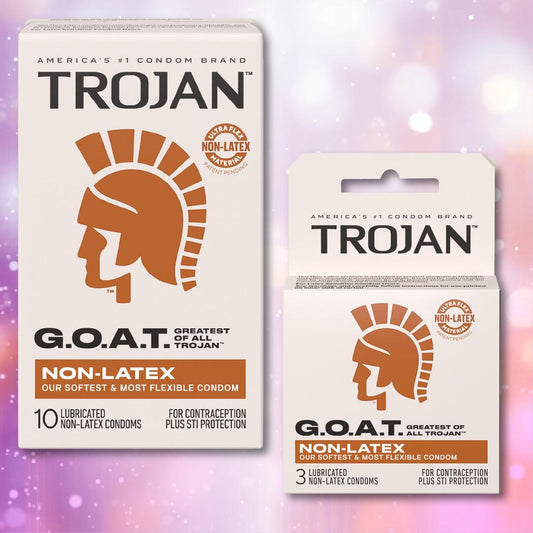 Two boxes of Trojan G.O.A.T. Non-Latex Lubricated Condoms from Trojan, featuring ultra flex comfort, are displayed against a purple and pink bokeh background. Each box displays a bronze Trojan helmet logo. 1080