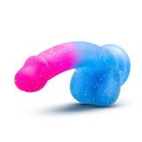 The Avant Chasing Sunsets Dildo - Mermaid by Avant is a brightly colored, dual-tone silicone object resembling a phallic shape. It has a pink tip that transitions into blue towards the base and is covered in a subtle glittery texture. This model features a sturdy suction cup base and is crafted from premium Puria platinum-cured silicone for superior quality.